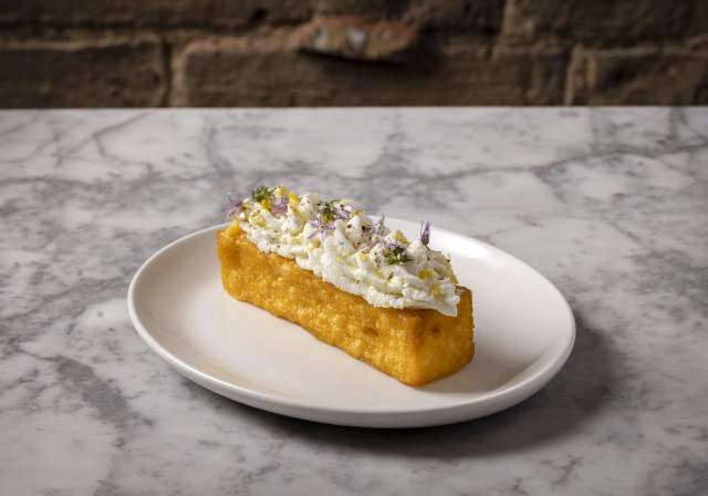 dish topped with whipped white sauce and herbs