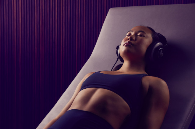 woman relaxing at gym with headphones on
