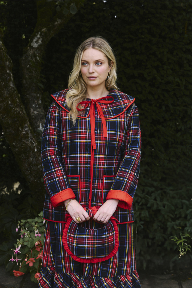 model posing in red and blue tartan jacket and matching skirt