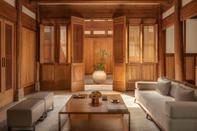 hotel villa lounge area with sofas and square table in natural wood