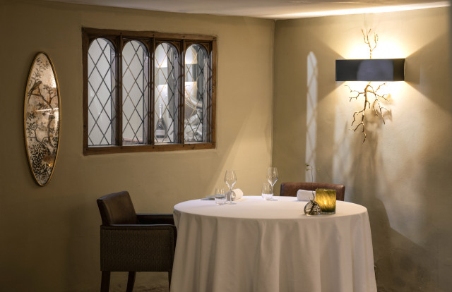 interior of restaurant with round table and two leather chairs