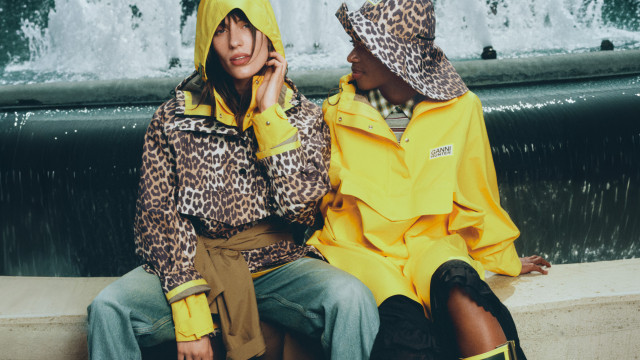 models wearing ganni x hunter wet weather garments by water fountain