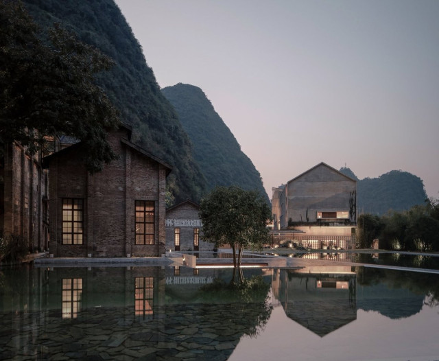old sugar mill transformed into a hotel with a pool in the front