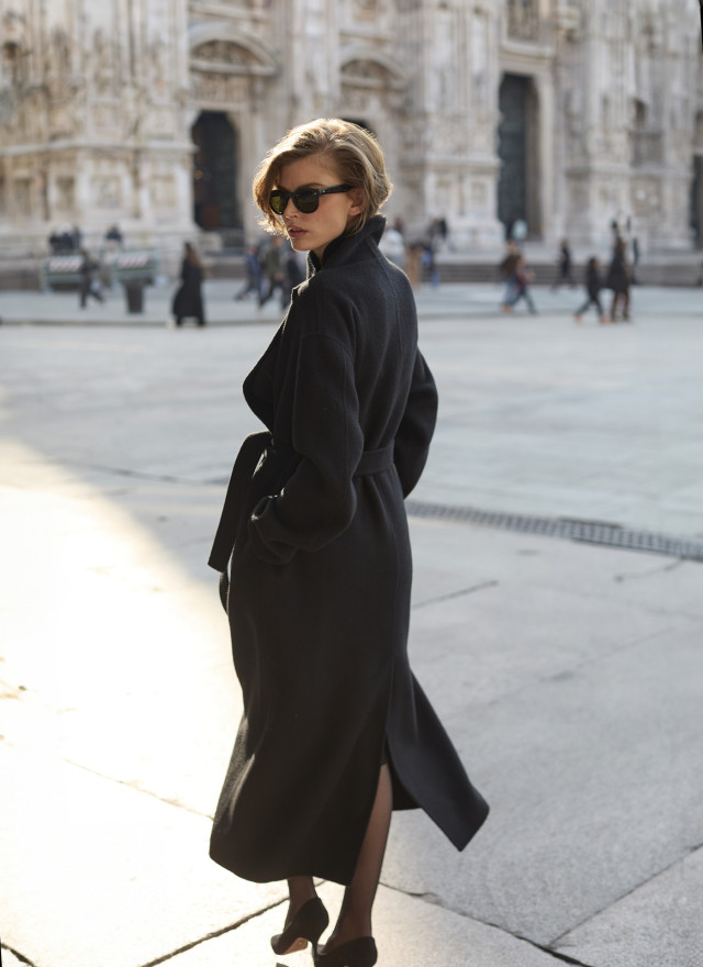 model posing in black wrap coat and sunglasses