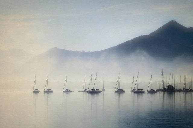 boats on lake zurich with mist surrounding them