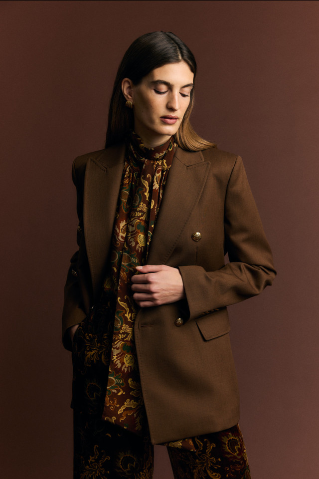 model posing in paisley shirt, trousers and chocolate brown blazer