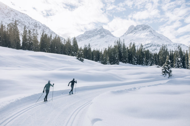 two people skiing in the mountains