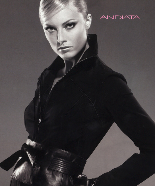 black-and-white model posing in black jacket and wide leather belt