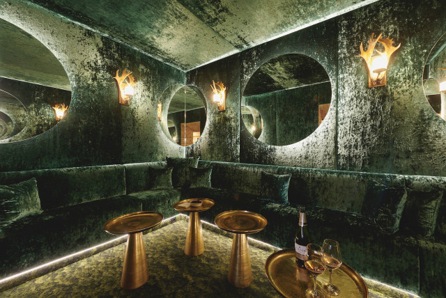 plush green bar area with gold round tables 