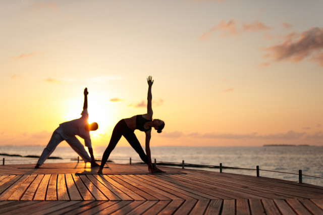 two people doing sunrise yoga