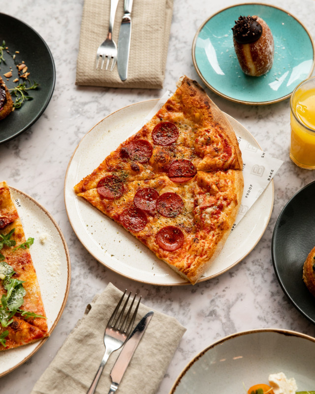 pizza on marble table with doughnut and orange juice