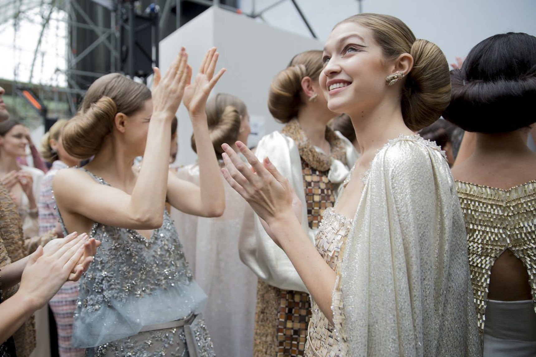 Models at Haute Couture fashion show clapping and smiling