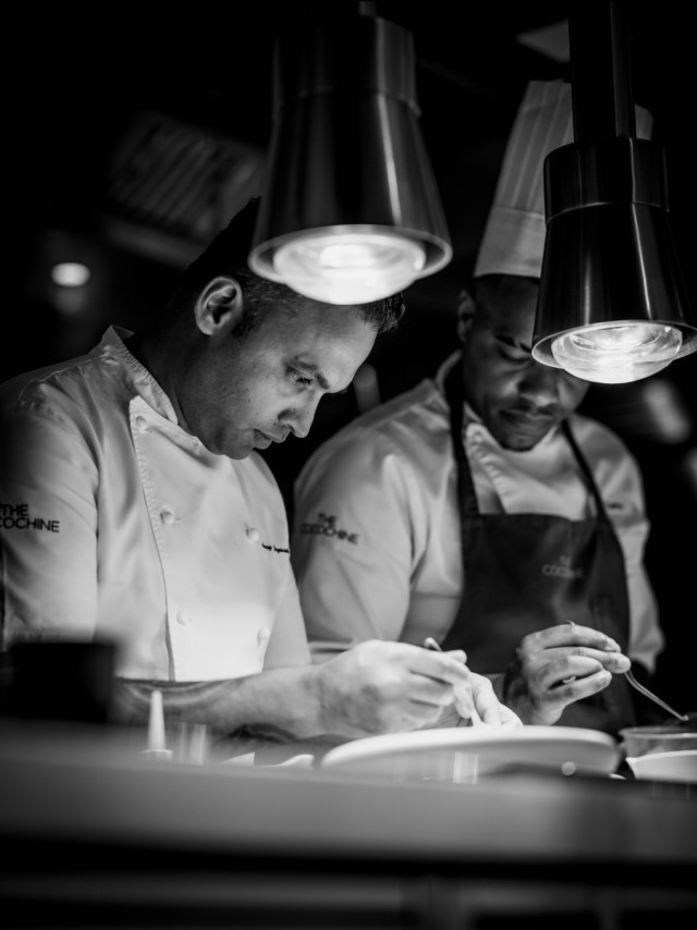 black-and-white photo of two chefs working in kitchen 