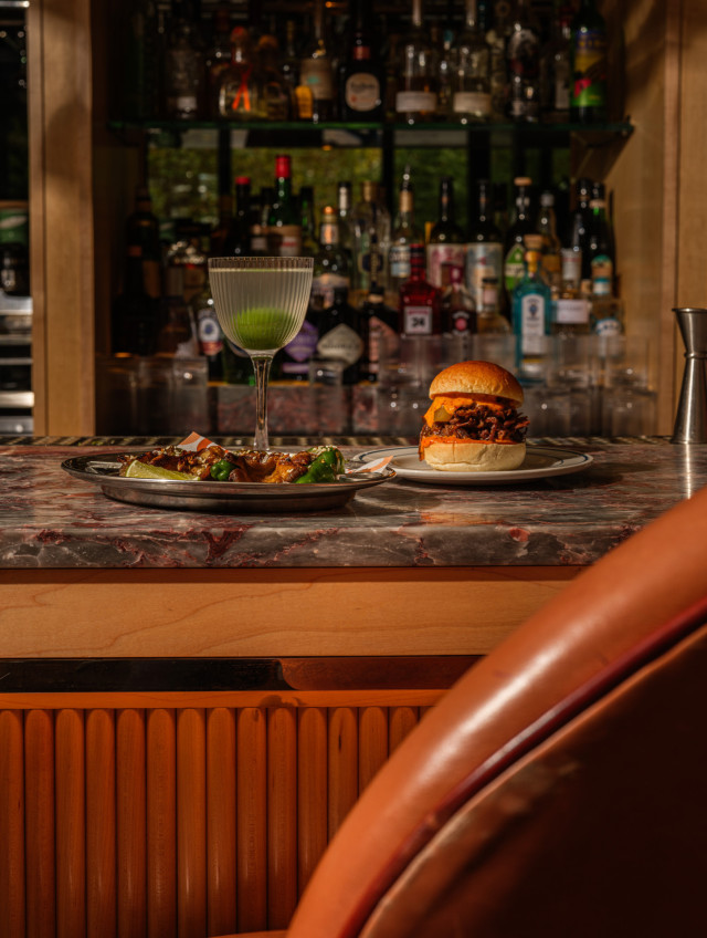 cocktail on bar top with burger