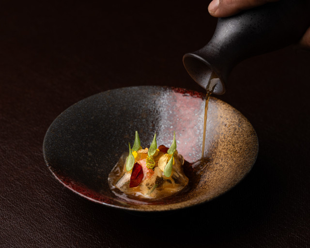 crab dish with sauce being poured over it