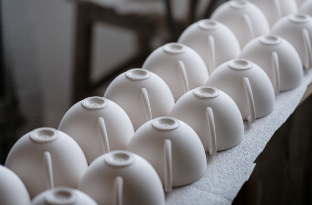 rows of porcelain cups placed upside down on bench
