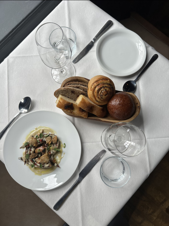 table in restaurant with one dish and bread basket