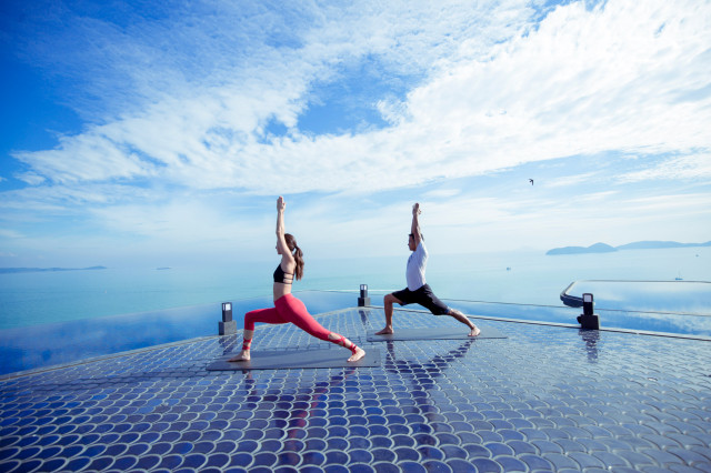 two people doing rooftop yoga