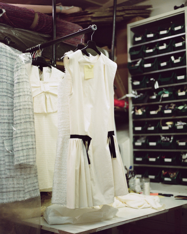 white dress with black bow detail hanging in workshop
