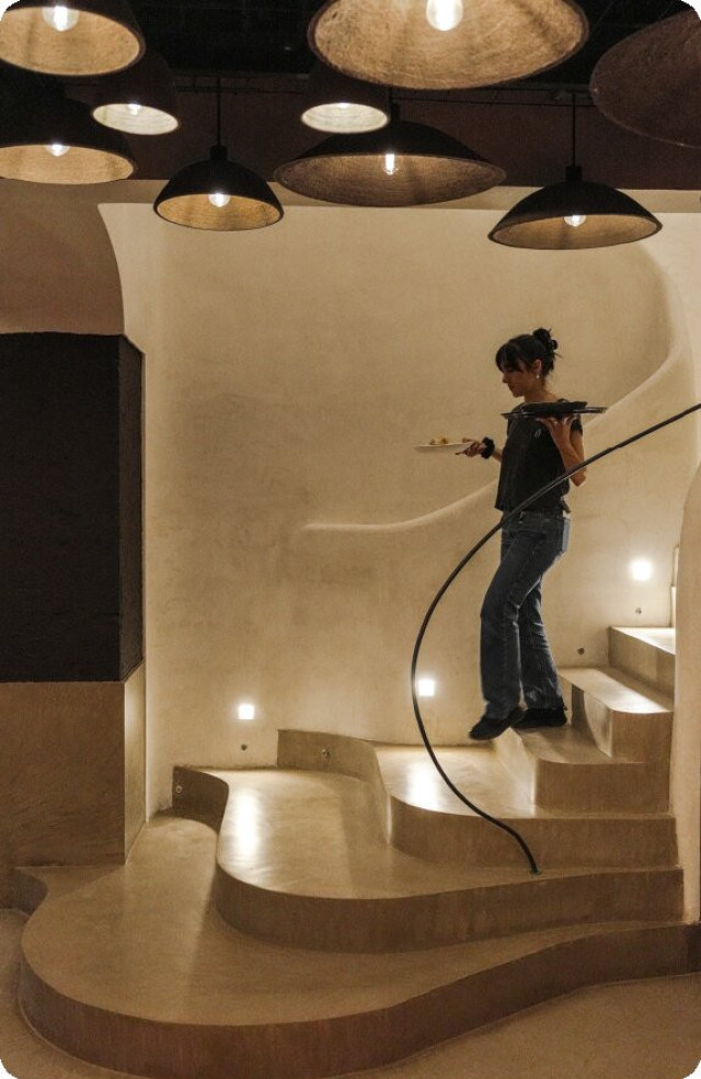 waitress walking down restaurant stairs holding two dishes