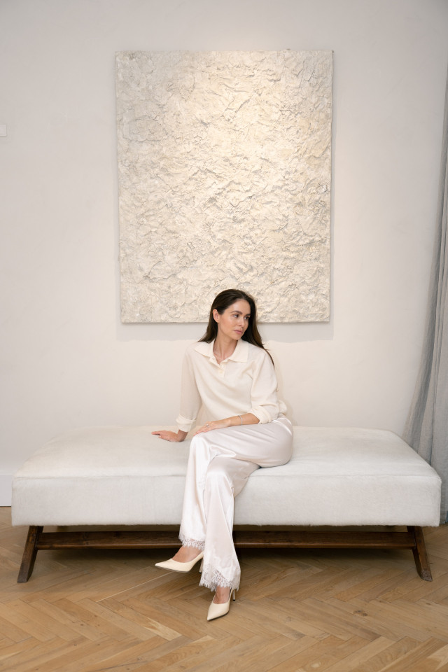 woman posing on white bench in white outfit