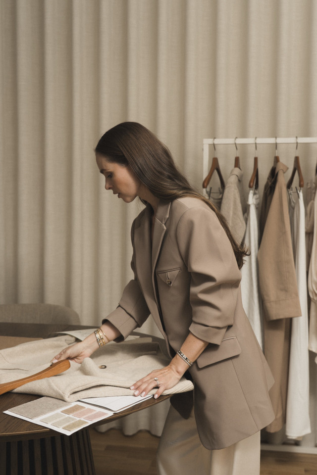 fashion designer looking at garments of clothing