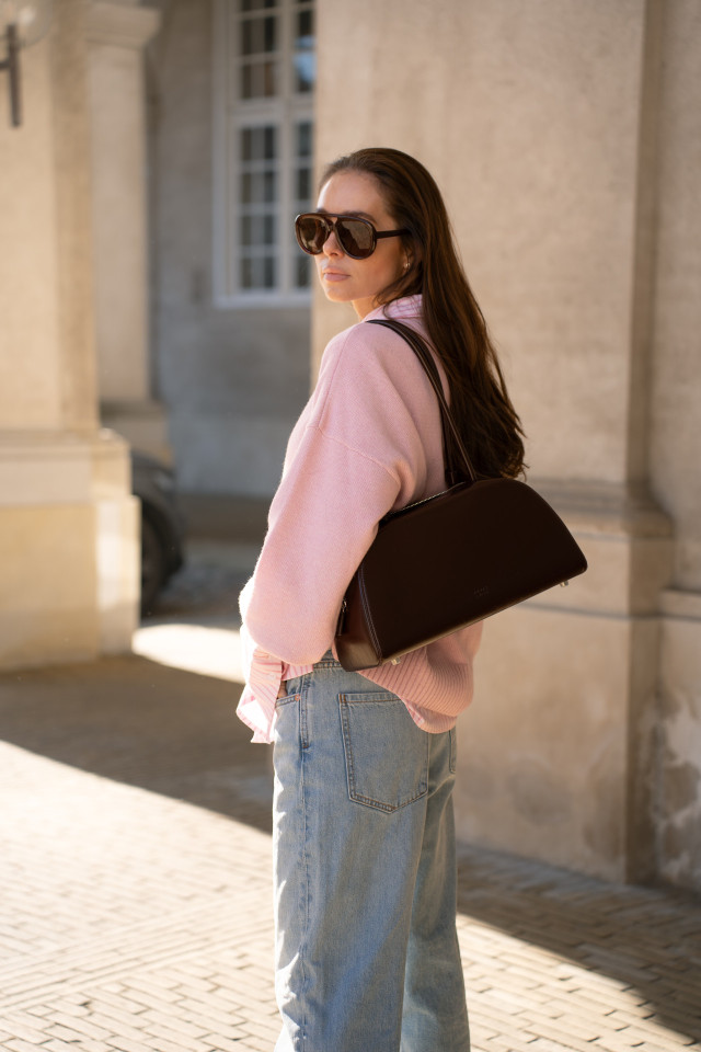 woman posing with brown handbag in the sun