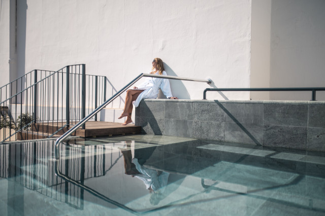 person relaxing by pool at hotel 