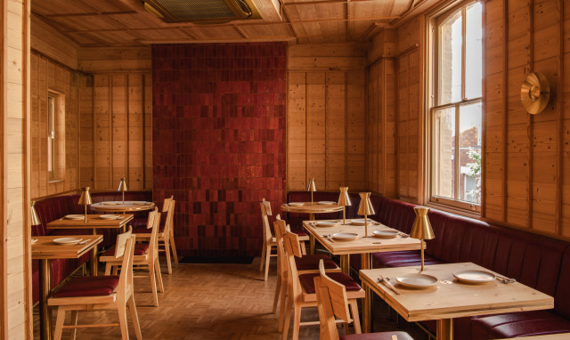 NAKIMUSHI restaurant interiors with wooden tables and red tiles on the wall