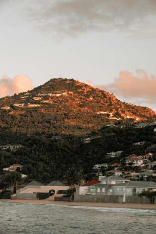 Beach with beach houses and a mountain behind in St. Barths.