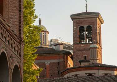 An old brick building with domes and a bell tower.