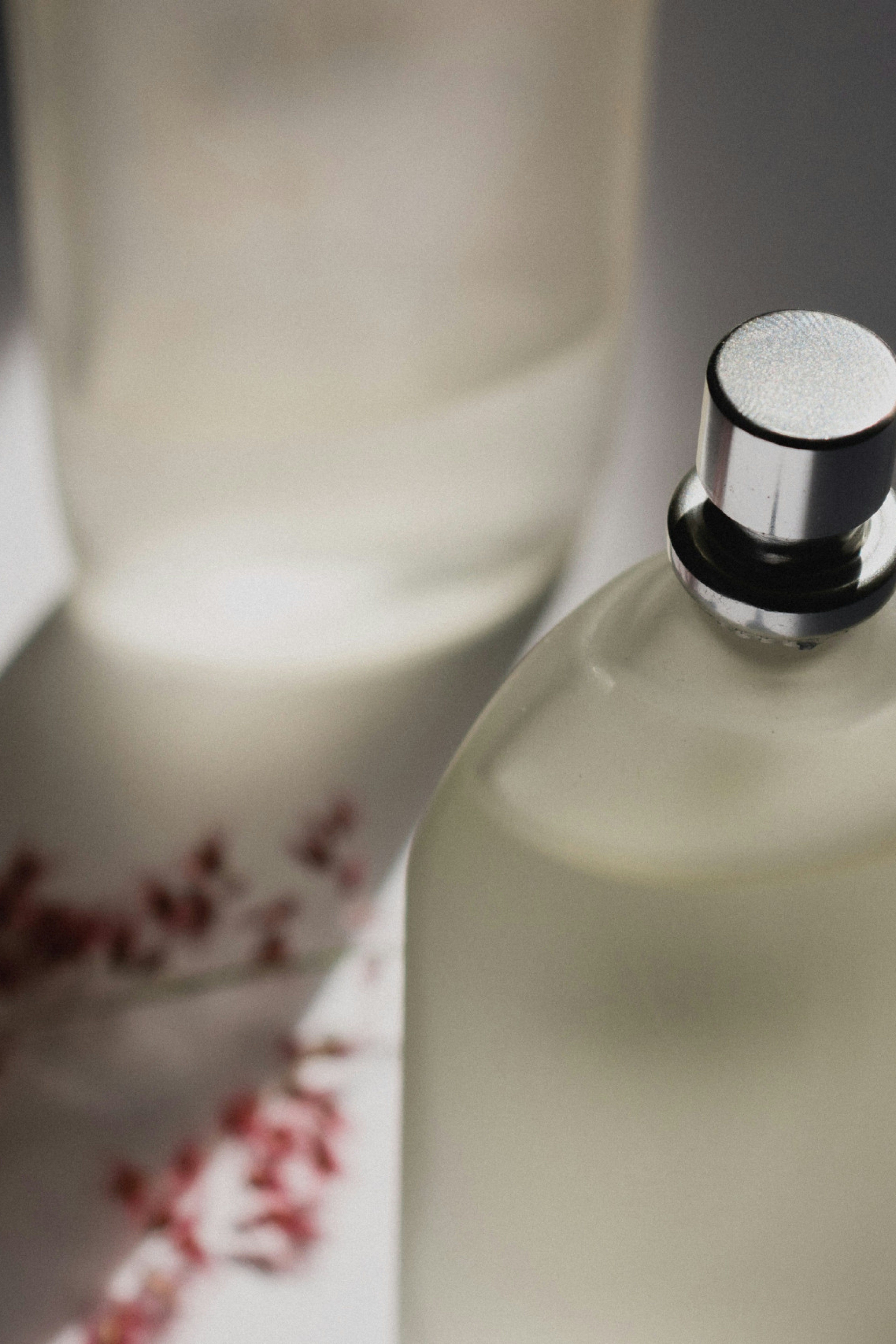 perfume bottle with rose petals in the background
