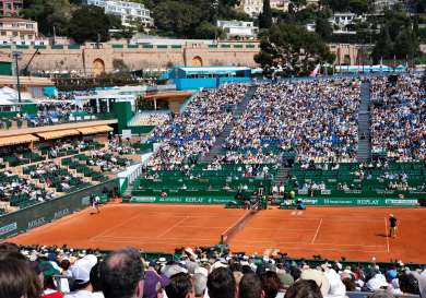 Filled tennis stadium with a 1 v 1 match occurring on the court.