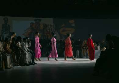 Runway with 4 models on it all wearing shades of pink/red.