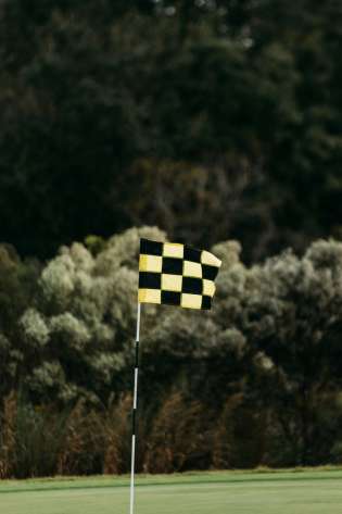 Yellow and black Chequered flag on a golfing green.