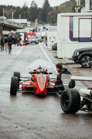 Red race car on a wet track.