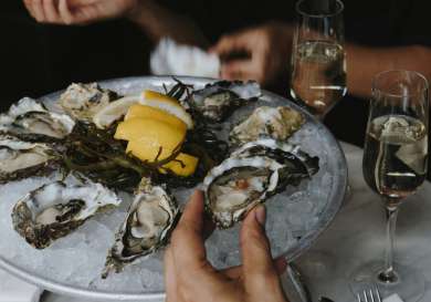 People eating oysters with glasses of champagne.