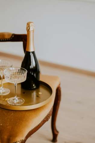 Velvet chair with tray and two glasses of champagne.