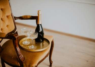 Velvet chair with tray and two glasses of champagne.