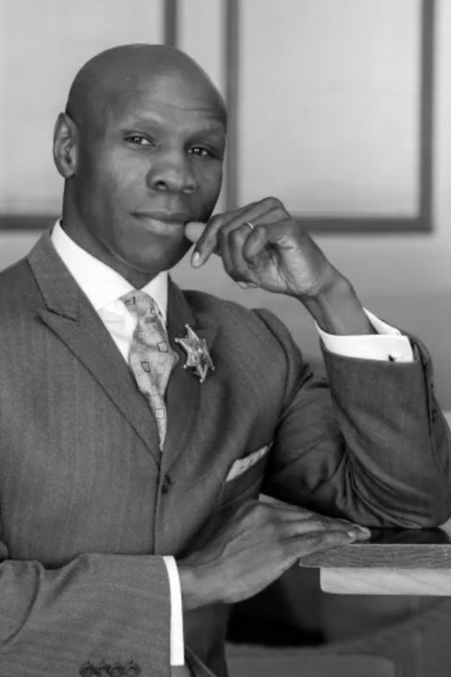 black and white photo of chris eubank sat at wooden table