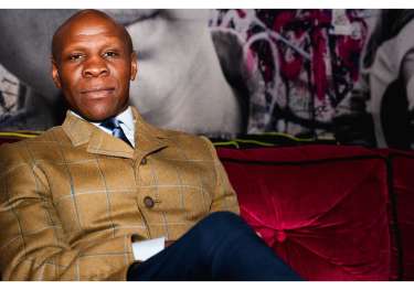 Photo of chris eubank on red velvet sofa .
