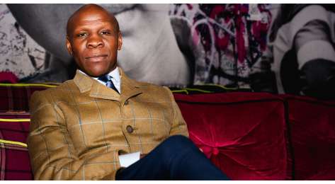 Photo of chris eubank on red velvet sofa .