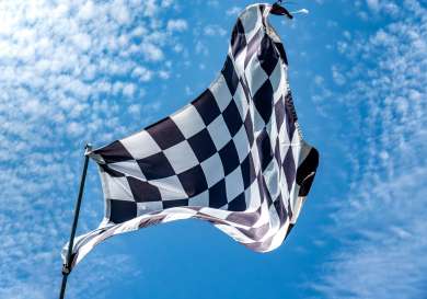 Chequered flag against blue sky.