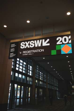 SXSW registration sign above a hallway.