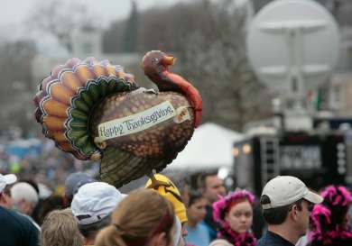 Small turkey balloon in crowd of people.
