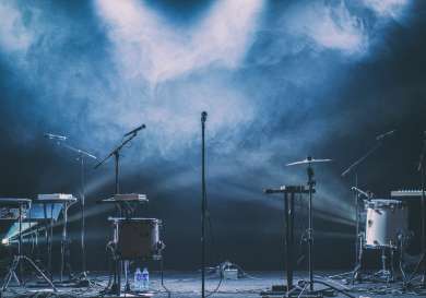 Drums and microphones on stage .
