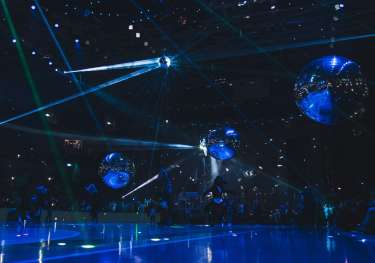 2025 Eurovision Song Contest Grand Final with dark blue lighting, 4 large mirror balls, and 1 disco ball.