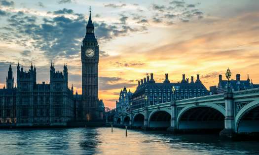 Westminster London during sunset behind the Thames.