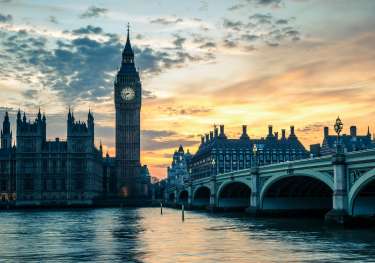 Westminster London during sunset behind the Thames.