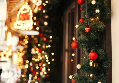 Festive decoration with an ornament-decorated garland and many lights.